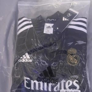 Svart Real Madrid fotbollströja från Adidas - Real Madrid tracksuit/dress storlek passar från 9-11 år gammal. Jag ska sälja den eftersom den kom fel storlek på min lillebror