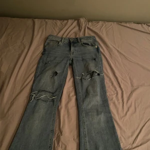 Blå bootcut jeans med slitningar - Snygga blå bootcut jeans med coola slitningar på benen.  Köpte på vinted! Skriv om ni har frågor eller prisförslag! Storlek xxs men passar även xs!