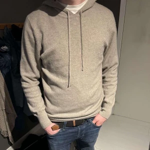 Beige hoodie från Soft Goat - Tjena, säljer nu min kashmire hoodie från soft goat. Säljer pågrund utav att den inte kommer till användning längre. Den är i storlek L men sitter som en större M. Den är i bra skick, enda är ett litet hål som gör att skicket blir lite sämre, hör av er vid fler frågor och funderingar!