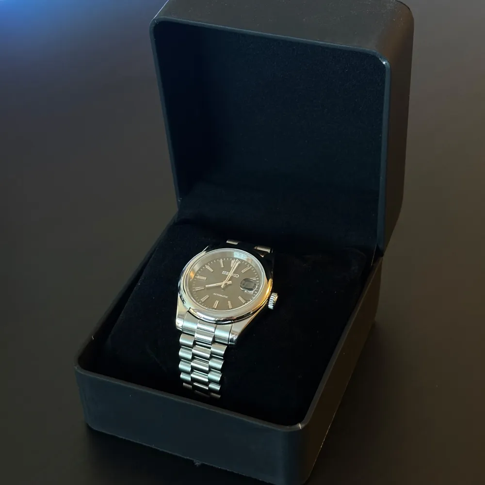 Nybyggd Seiko mod Datejust 40mm, NH35 automatiskt urverk, Safir glas, Stainless steel presidential länk (kan även anpassa storleken, om önskat) Grå urtavla med sunburst-effekt (skimrar/skiftar färg i olika ljus) Lume visare (lyser i mörkret), box ingår. Asusteet.