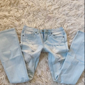 Ljusblå bootcut jeans med hål - Verkligen världens snyggaste och skönaste ljusblå jeans med superlåg midja som tyvärr är för små😭 De är i modellen low Rise bootcut vilket kan ses på sista bilden💞De är även rätt så stretchiga💞Midjemått: ca 36-37 cm +stretch💞 Innerbenslängd: Ca 80-81 cm💞 Grenhöjd: ca 17 cm💞Skriv vid frågor eller bilder på mått eller annat💞 (För små så kan tyvärr inte ta några bilder med de på) TYCK GÄRNA PÅ KÖP NU!💞