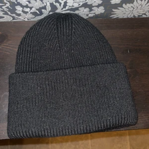 Svart satén mössa - Snygg svart mössa med satintyg på insidan för att göra håret mindre frissigt. Aldrig använd.