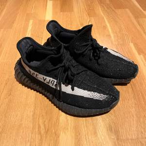 Säljer ett par Adidas Yeezy Boost 350 i färgen Oreo.Skorna är i gott skick med lite slitage på sulan. Skorna säljs nytvättade!!