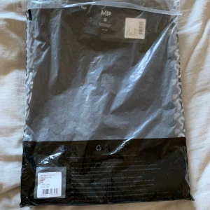 Svart linnetopp från MP - Säljer en svart linnetopp från MP. Perfekt för träning med sin lätta och bekväma passform. Linnet är tillverkat i ett mjukt material som andas, vilket gör det idealiskt för intensiva träningspass. Helt nytt och oanvänt, fortfarande i originalförpackning.