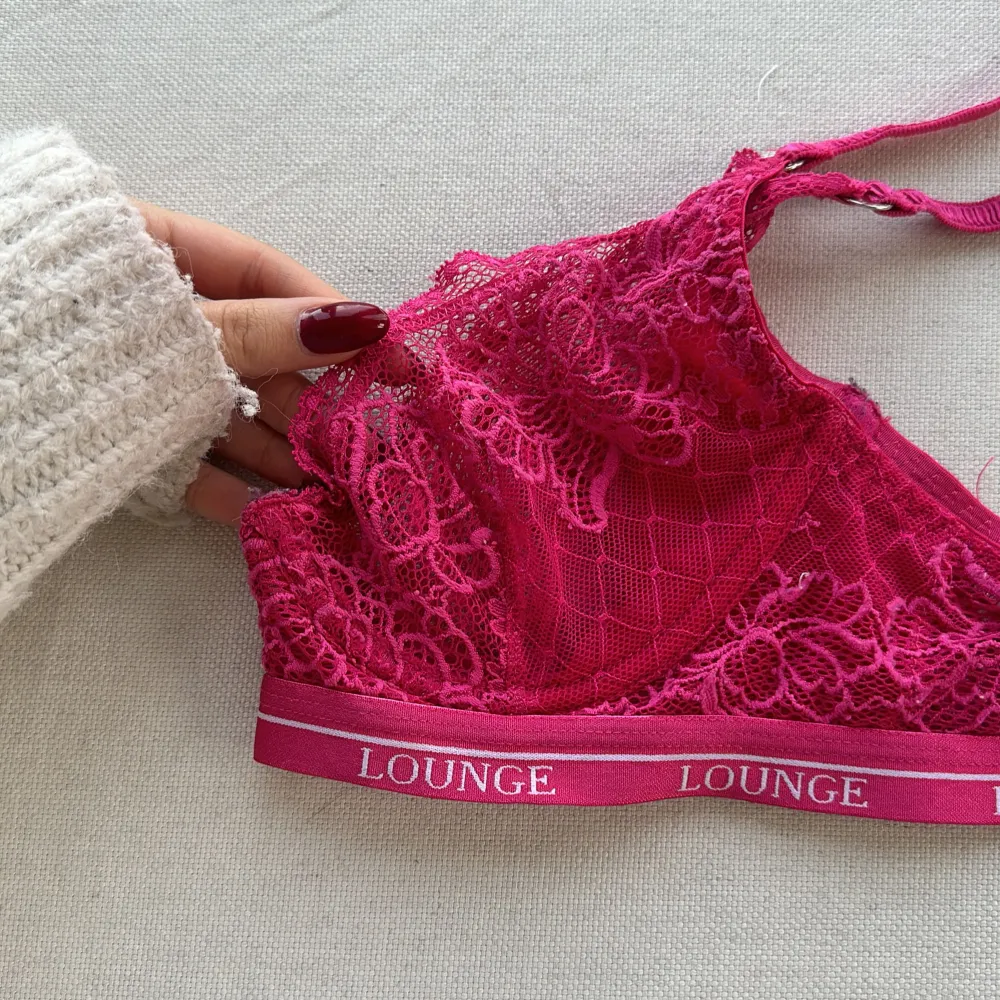 Säljer en superfin rosa spets-BH från Lounge. Den har en elegant spetsdesign och justerbara axelband. Perfekt för att känna sig både bekväm och snygg. Resårbandet har Lounge-loggan tryckt runtom. Passar perfekt till vardags eller speciella tillfällen. 💖. Yläosat.