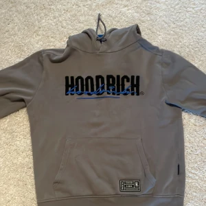 Hoodrich hoodie  - Säljer min hoodrich hoddie som jag har använt bara några gånger. Färgen är grå och blå väldigt snygg. Väldigt bra nu till hösten med en snygg huddie. 
