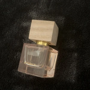 Parfym från Rituals med trälock - Säljer en elegant parfym från Rituals. Flaskan är fyrkantig och genomskinlig med en lyxig känsla. Den har ett stilrent trälock som ger en naturlig touch. Perfekt för både vardag och speciella tillfällen. Doften är subtil men ändå minnesvärd. Passa på att köpa denna fina parfym!