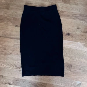 Svart kjol från H&M Divided - Snygg svart kjol från H&M Divided i storlek S. Kjolen är knälång och har en tight passform som framhäver figuren. Perfekt för både vardag och fest! 🖤
