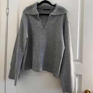 Ginatricot  - Grå tröja från Ginatricot. God skick. Använd endast 2 tillfällen. Öppningen vid händerna och på sidorna längst ner på midjan slutet av tröjan.