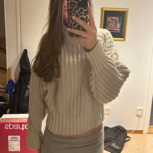 Beige stickad tröja - Säljer en supermysig beige stickad tröja som är perfekt för höst och vinter. Den har en croppad passform och långa ärmar, vilket gör den både trendig och bekväm. Perfekt för att hålla sig varm och snygg under kyliga dagar!