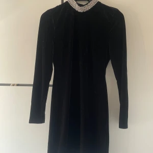 Klänning - Svart klänning med detaljer vid halsen, vet ej vart denna är köpt och har aldrig använt den. Skriv vid fler bilder. Skulle nog säga att denna passar en S/M ❌ står ej för frakt❌