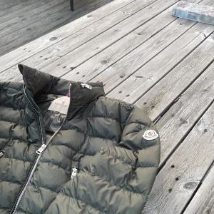 Moncler jacka - Grön moncler jacka. Perfekt för hösten när det börjar bli lite kallare ute. Svagt missfärgat märke på insidan men annars fin. Pris kan sänkas vid snabb affär