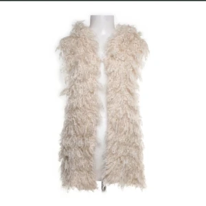 Beige pälsväst - Säljer en supermjuk och fluffig beige pälsväst. Perfekt för att lägga till lite glam till din outfit. Västen är gjord av 80% polyamid och 20% polyacryl, vilket gör den både lätt och varm. Perfekt för höst och vinter!