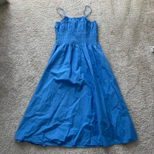 Blå långklänning med smala axelband - Säljer en superfin blå långklänning med smala axelband. Perfekt för sommardagar eller en avslappnad fest. Endast använd en gång 