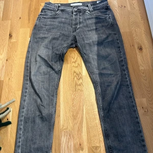 Grå jeans från Pepe Jeans - Säljer ett par grå jeans från Pepe Jeans i bra skick. De har en klassisk femficksdesign och en knappgylf. Jeansen är i regular fit och passar perfekt för både vardag och fest. De har snygga detaljer på bakfickorna som ger en extra touch.