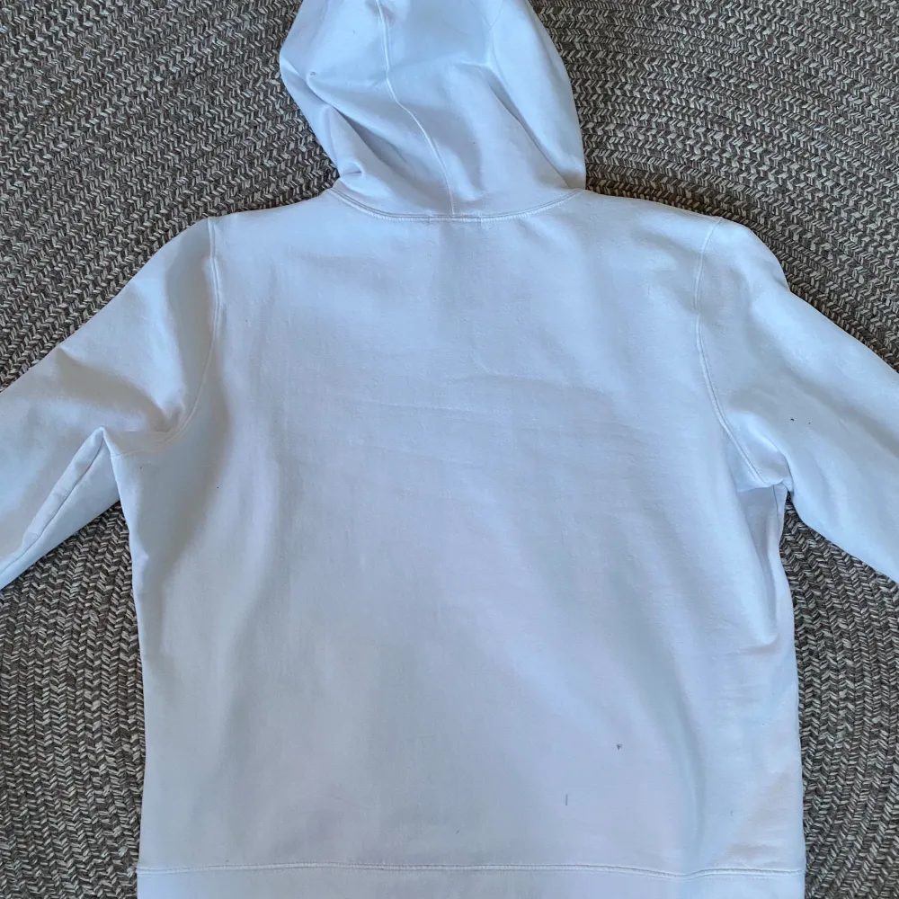 Säljer en vit hoodie från GAP. På lappen står det XL, men den passar S/M. Den har en klassisk design med GAP-loggan i blått på framsidan. Perfekt för en avslappnad stil och passar bra till både höst och vår. Hoodien är i bra skick med en mjuk insida för extra komfort. Den har ett litet hål som man kan se på sista bilden, men det är inget som syns när man har på sig den. Hoodies.