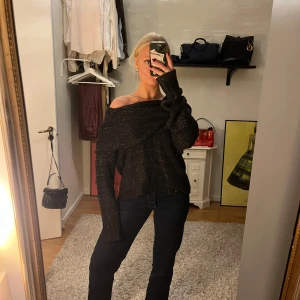 Svart offshoulder stickad tröja - Säljer en supermysig svart stickad tröja med offshoulder-design. Perfekt för höst och vinter, den är både stilren och bekväm. Tröjan har långa ärmar och en lös passform som gör den lätt att matcha med jeans eller kjol. 🖤