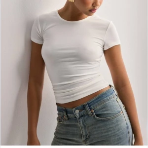 Vit tight t-shirt - Säljer en stilren vit topp med korta ärmar.  HELT ny aldrig använt❣️Perfekt som basplagg, som man sedan kan styla med annat! Toppen har en tight passform som framhäver figuren.❣️