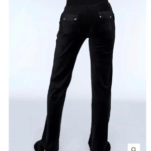 Svarta juicy byxor med fickor - Säljer ett par svarta juicybyxor i mycket bra skick. De har en bekväm passform och är perfekta för både chill och vardag. Byxorna har snörning i midjan och praktiska fickor bak. Perfekta för höst och vinter!