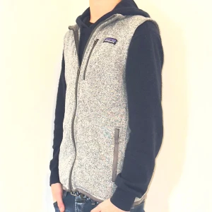 Grå fleeceväst Patagonia - Säljer en snygg grå fleeceväst från Patagonia i mycket bra skick. Västen har en dragkedja framtill och en praktisk bröstficka med dragkedja. Perfekt för lager-på-lager under höst och vår. Den är bekväm och stilren, idealisk för både vardag och friluftsliv.