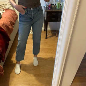 Blå jeans med hög midja - Säljer ett par klassiska blå jeans med hög midja. De har en straight passform och är perfekta för vardagsbruk. Jeansen är i bra skick och passar till det mesta i garderoben. Perfekta för både vår och höst!