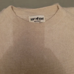 Beige kashmirtröja från Soft Goat - Säljer en supermjuk och stilren beige tröja från Soft Goat i 100% kashmir. Perfekt för kyliga dagar med sin varma och sköna känsla. Tröjan har en klassisk design med rund hals och långa ärmar. Passar både till vardags och lite finare tillfällen. 🧡