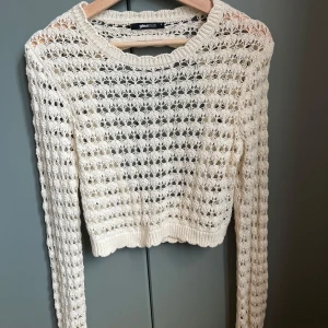 Vit stickad tröja  - Säljer en superfin vit / creme färgad stickad tröja från Gina Tricot. Den är lite  croppad och har en öppen rygg som ger en snygg look. Perfekt för layering! Jättefina detaljer längs hela tröjan 💖knappt använt 