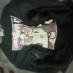 Svart Hello Kitty tröja från Sanrio - Säljer en superfin svart tröja med Hello Kitty-tryck i rosa och vitt från Sanrio. Perfekt för alla Hello Kitty-fans! Tröjan är i storlek L och har långa ärmar. Den är både bekväm och stilren, perfekt för vardagsbruk. 🎀 köptes i Barcelona!