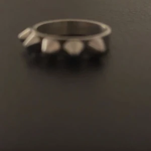 Silvrig ring med nitar - Cool ring i silver med nitar runtom. Perfekt för att ge din outfit en edgy touch. Passar både till vardags och fest. 🖤