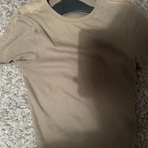 Grön ribbad t-shirt från Bik Bok - Säljer en snygg grön ribbad t-shirt från Bik Bok i storlek S. Lite fläckar men märks inte, jätte fin tröja💕