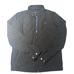 Svart quiltad jacka från Gant - Säljer en snygg svart quiltad jacka från gant bara använd en gång storlek S