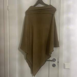 Säljer en supermysig beige poncho perfekt för höst och vår. Den är i ett mjukt material och har en lös passform som gör den lätt att slänga över vilken outfit som helst. Perfekt för att hålla sig varm och stilren samtidigt! 🍂