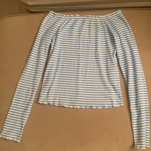 Långärmad off shoulder topp - Blå/vit randig off shoulder topp. Storlek M. Köpt på Nelly men märket är Pieces.