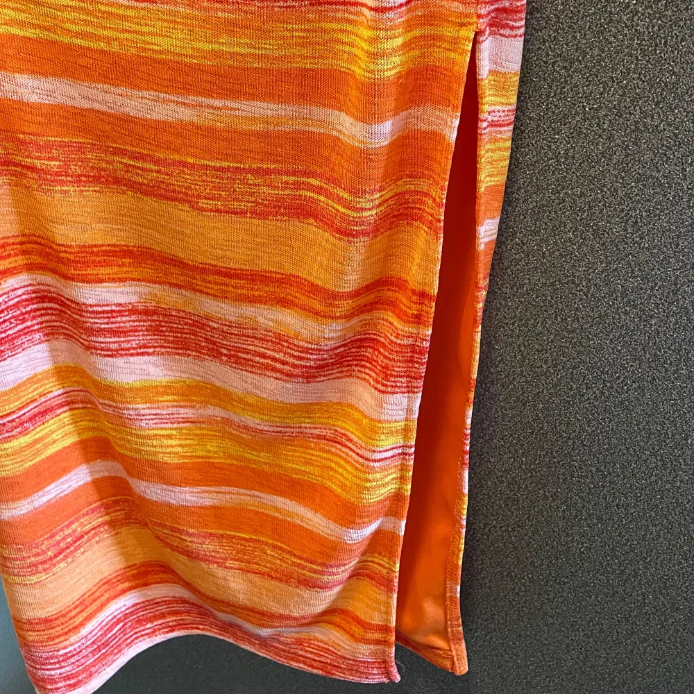 Tubklänning med slits på ena sidan från Shein i stl xs. Orange mönstrad. En liten tråd som sticker ut men som knappt syns (se sista bilden), i övrigt fint skick. Material: 95% polyester, 5% elastan.. Klänningar.