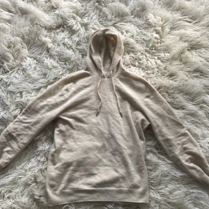 Merinoull Hoodie - Säljer denna supersnygga Merionoull Hoodie i färgen beige och den är i storlek M. Har knappt använt den och är i mycket bra skick 9/10.