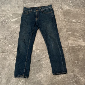  Nudie Gritty Jackson Blue slate - Ett par Nudie Gritty Jackson Blue slate jeans. Storlek : W 31 L 30 Skick: 9/10  Små slitningar på baksidan samt tvättlappen smått blåfärgad