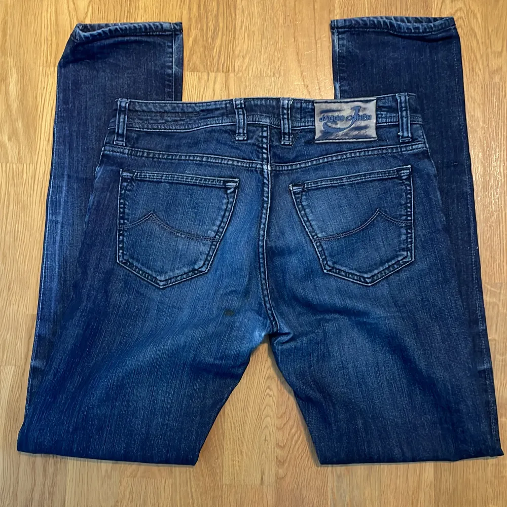 Riktigt schyssta Jacob Cohen jeans med en skön mörkblå tvätt och unika cohen detaljer som ”J” över myntfickan. Size 32. Skick 8/10 då de är i bra skick bortsätt från att lappen där bak med hästskin är lite sliten, bild 2. Priset är ej hugget i sten.. Jeans & Byxor.