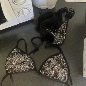 Svart bikini med paljetter - Snygg svart bikini med glittrande paljetter. Toppen har trekantsform och knytband. Älskar detta bikini sett men tyvärr har jag växt ur den, storlek 34 passar någon med lite mindre bröst. 