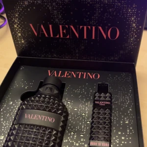 Valentino Uomo Born in Roma parfymset - Exklusivt parfymset från Valentino med doften Uomo Born in Roma. Innehåller en elegant flaska med svart, nitat mönster och en matchande mindre flaska. Perfekt för den stilmedvetne som vill ha en sofistikerad och modern doft.