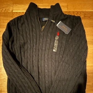 Svart quarter zip stickad tröja, Polo Ralph Lauren, XL - Säljer en Quarter Zip, stickad tröja i storlek XL, står ej för postnordslarv eller returer.