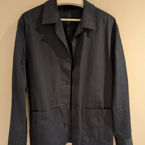 Mörkblå overshirt från Massimo Dutti stl M - Snygg mörkblå overshirt med knappar framtill och två stora fickor. Från Massimo Dutti i stl Medium. Perfekt för lager-på-lager-stil och passar bra till både vardag och mer uppklädda tillfällen.