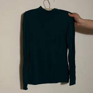 Mörkgrön långärmad tröja - Snygg mörkgrön långärmad tröja med hög krage (nästan polo). 