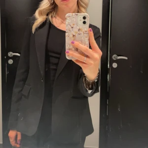 Svart kavaj - Snygg svart kavaj med klassisk passform. Perfekt för en stilren look. Extraknappar medföljer.