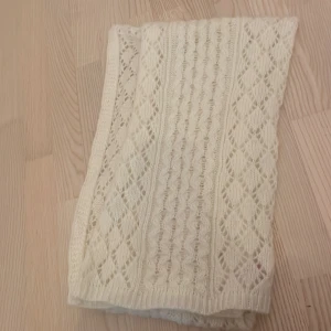 Vit halsduk - Säljer en vacker vit stickad halsduk från Indiska med ett detaljerat mönster. Den har används fåtal gånger. Den e ca 2,5 meter. Skriv för fler bilder 💞