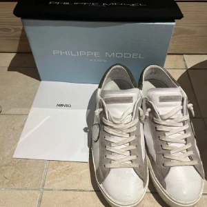 Vita sneakers från Philippe Model - Snygga vita sneakers från Philippe Model med grå detaljer och snörning. Dem är lite mer slitna än på bilden men fortfarande i bra skick, skriv för mer bilder 