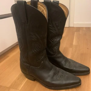 Svarta cowboy boots från Sendra - Snygga svarta cowboy boots från Sendra i skinn med dekorativa broderier. 