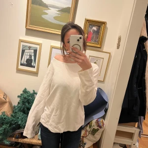 Vit långärmad tröja - Säljer en stilren vit långärmad tröja med en avslappnad passform. Perfekt för en casual look och lätt att matcha med olika outfits.