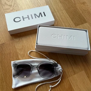 CHIMI 02 Grey - Snygga transparenta solglasögon från CHIMI med mörka linser. De har en stilren design och kommer med ett praktiskt fodral och putsduk.