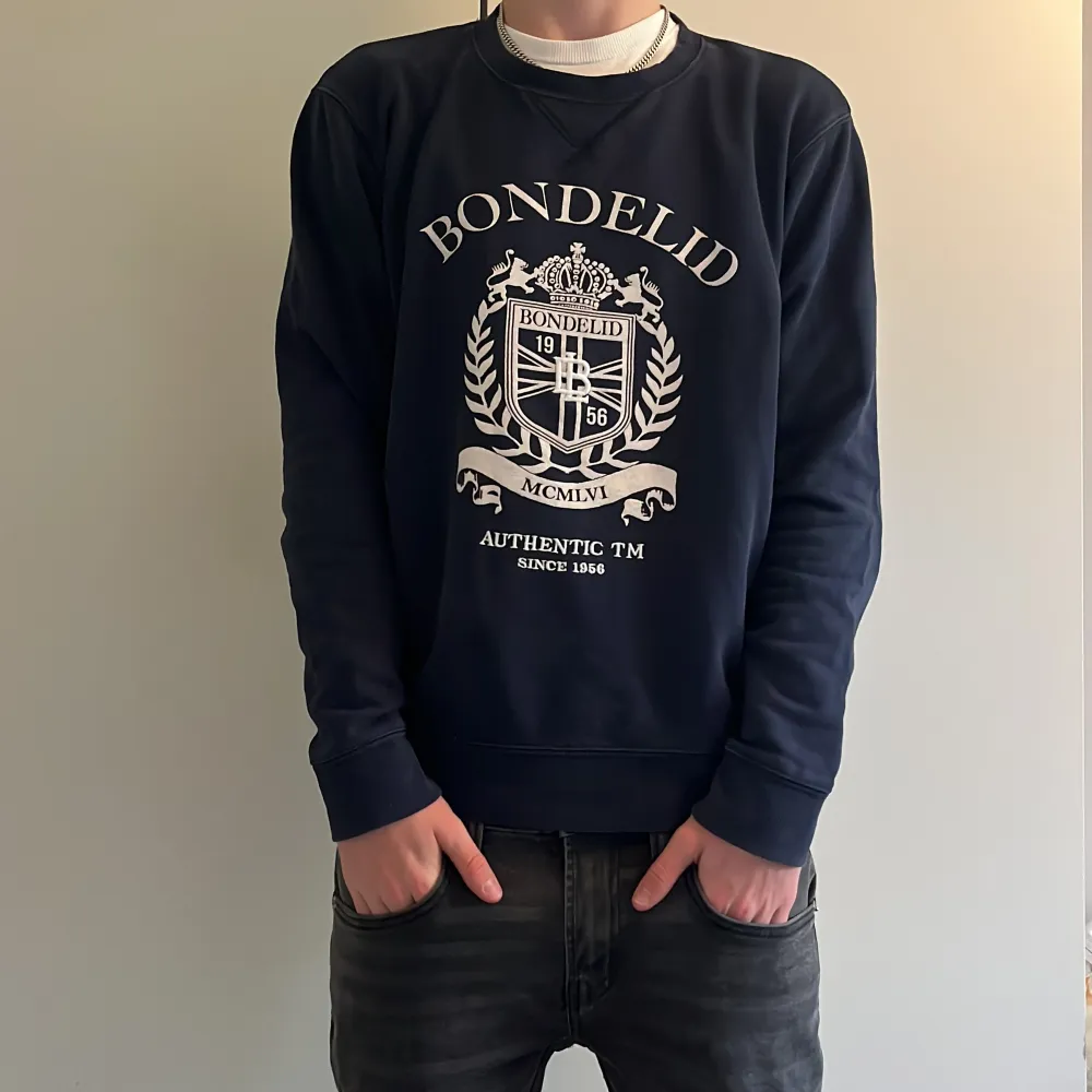 En mörkblå Bondelid tröja med ett fet tryck på framsidan, för endast 199kr. Storleken på tröjan är M. Hoodies.