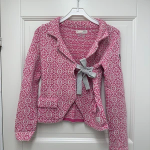 Rosa mönstrad jacka från Odd Molly - Säljer en superfin rosa och vit mönstrad jacka från Odd Molly💗Den har långa ärmar och en snygg knytning framtill med en grå rosett. Perfekt för vår och höst!💗 Använd en gång!